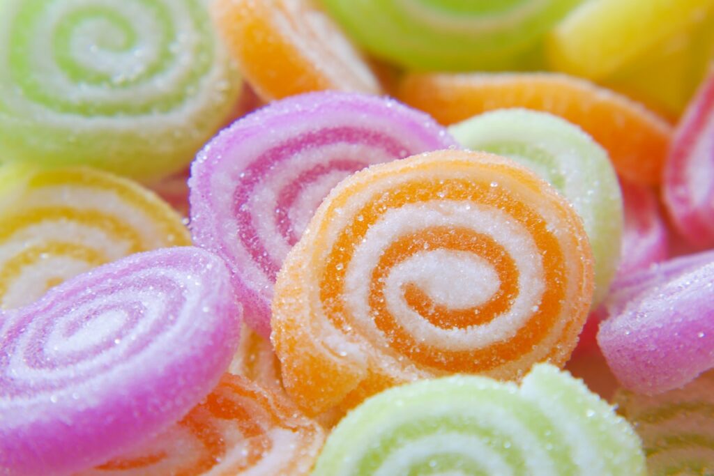 Colourful spiral-shaped sugar-free sweets coated in sugar crystals, perfect for diabetic-friendly indulgence and nostalgic sweets for diabetic diets.